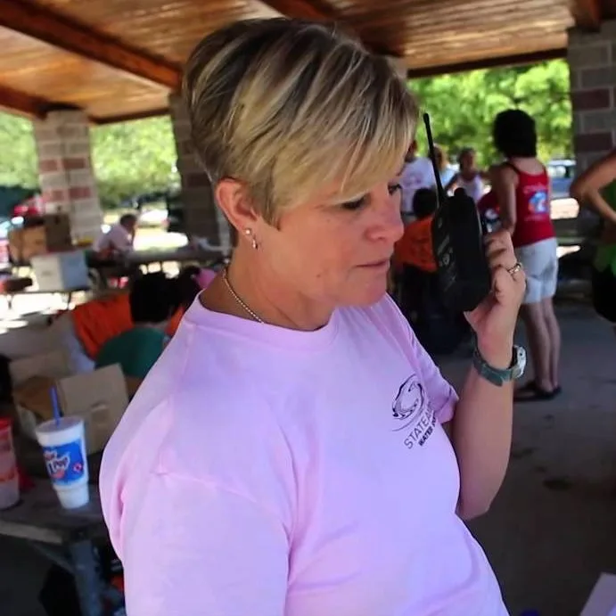 adult female volunteer working at the registration desk talking on a walkie talkie