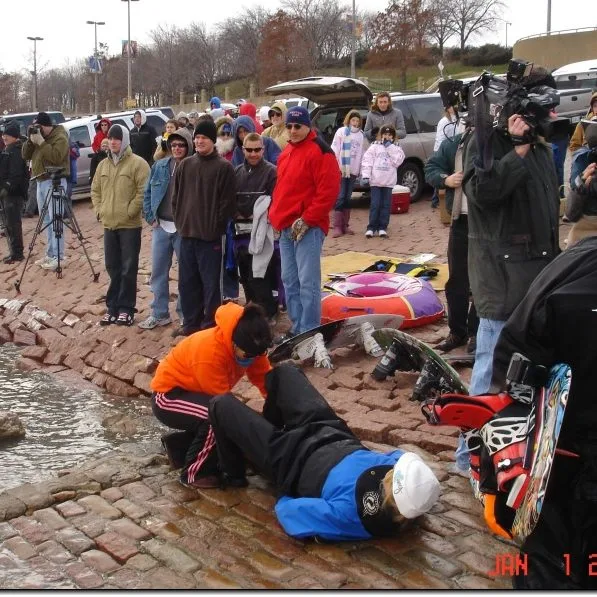 group of people, at the St. Louis Riverfront, watching a skier who is skiing the Mississippi River